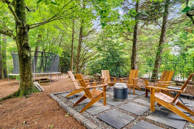 view of patio with a trampoline and an outdoor fire pit