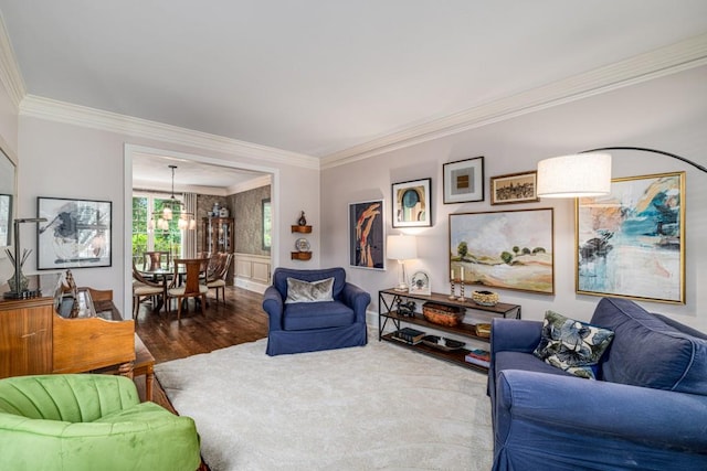 living room with ornamental molding, wood finished floors, and a chandelier