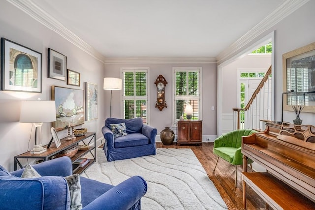 living room featuring wood finished floors, plenty of natural light, ornamental molding, and stairway
