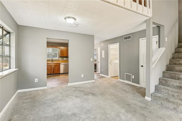 kitchen featuring sink, light hardwood / wood-style flooring, a textured ceiling, and appliances with stainless steel finishes