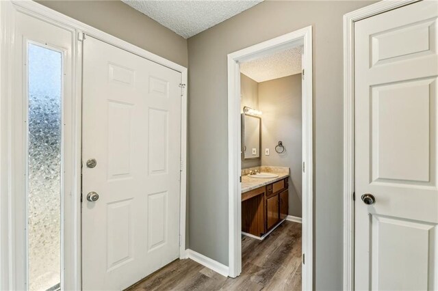 laundry area featuring dark hardwood / wood-style flooring, a textured ceiling, and washer and clothes dryer