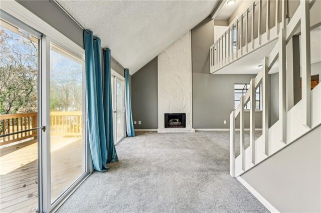 unfurnished living room with carpet floors, a fireplace, and a high ceiling