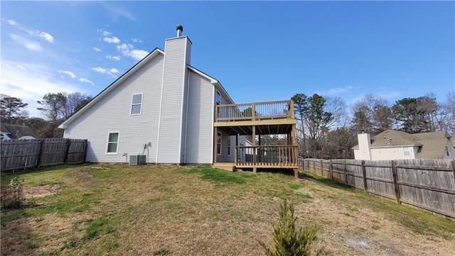 back of house featuring a deck, a fenced backyard, and a lawn