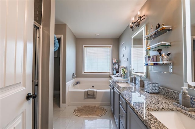 full bath featuring double vanity, baseboards, a bath, and a sink
