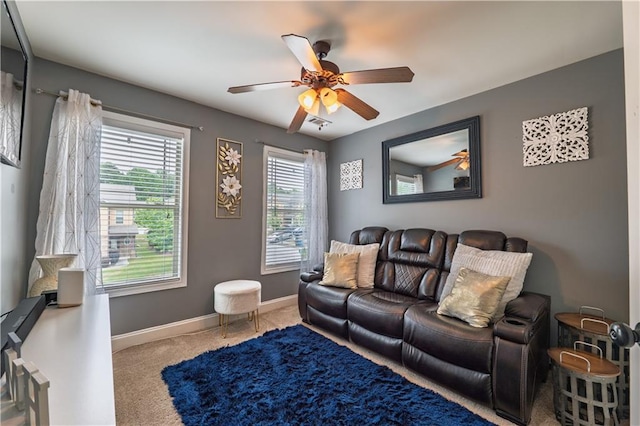 carpeted living area featuring a ceiling fan and baseboards