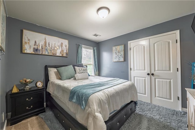 bedroom with carpet flooring, visible vents, and a closet