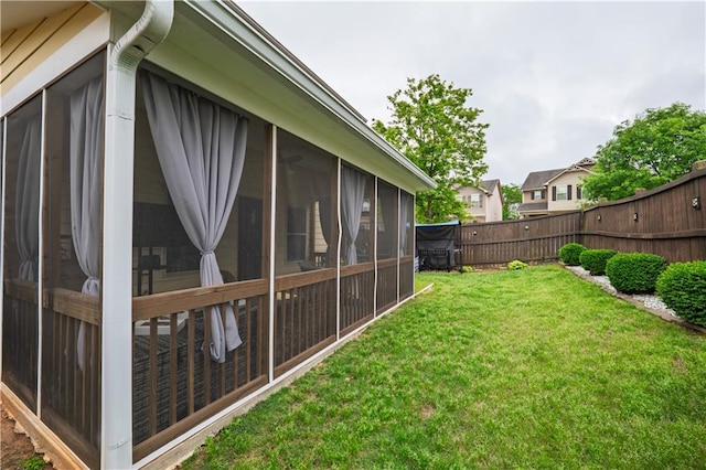 view of yard with a sunroom and a fenced backyard