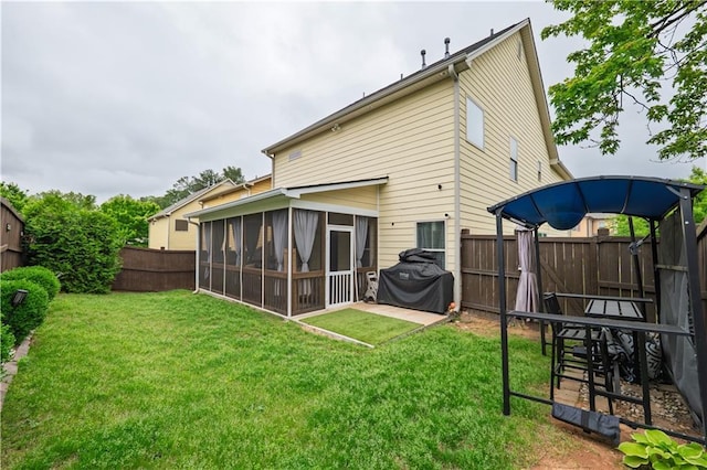 back of house with a sunroom, a fenced backyard, and a yard