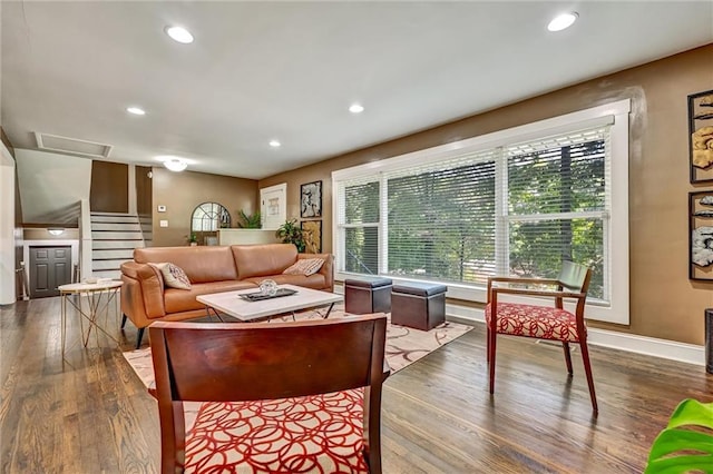 living room featuring stairs, recessed lighting, baseboards, and wood finished floors