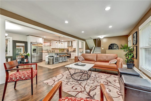 living room with stairs, wood finished floors, and recessed lighting