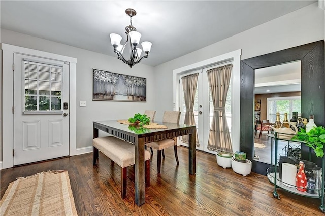 dining room featuring a chandelier, french doors, wood finished floors, and baseboards