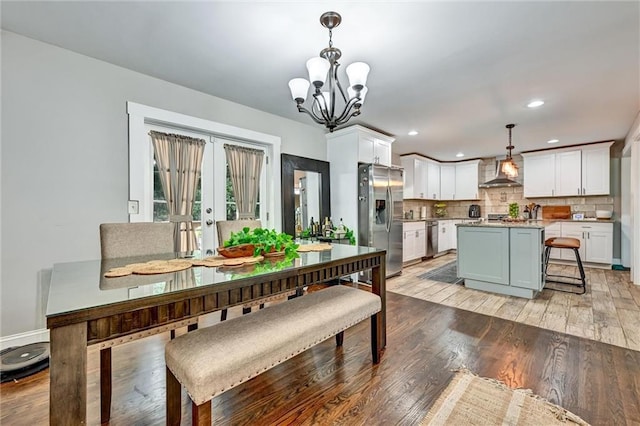 dining room with french doors, recessed lighting, an inviting chandelier, and light wood-style floors