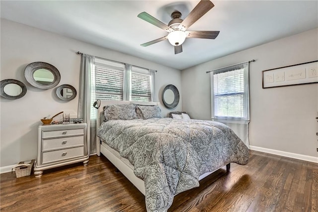 bedroom with multiple windows, dark wood finished floors, a ceiling fan, and baseboards