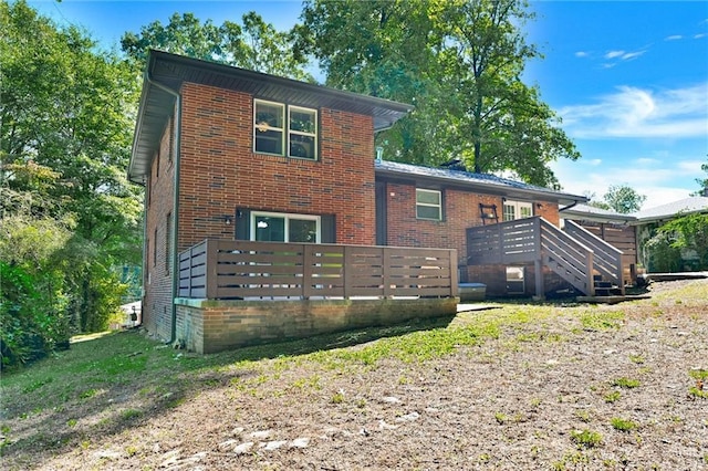 view of front of house featuring brick siding and a wooden deck