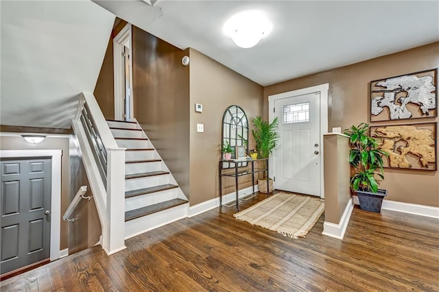 foyer with stairway, wood finished floors, and baseboards