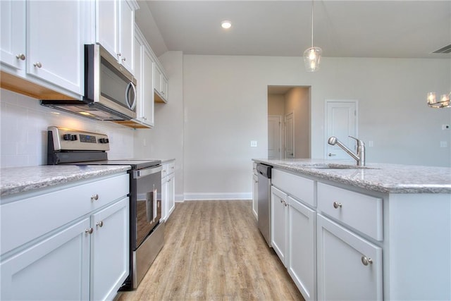 111 Ginger Trl, Homer, GA 30547 - kitchen featuring appliances with stainless steel finishes, a sink, light wood-type flooring, decorative backsplash, and white cabinets