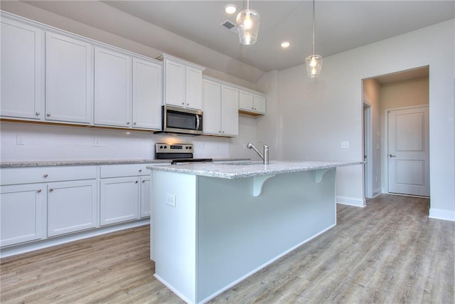 111 Ginger Trl, Homer, GA 30547 - kitchen with stainless steel appliances, a sink, light wood finished floors, a kitchen island with sink, and white cabinetry