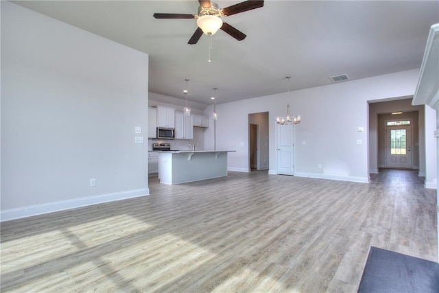 111 Ginger Trl, Homer, GA 30547 - unfurnished living room featuring a chandelier, light wood-style floors, ceiling fan, and baseboards