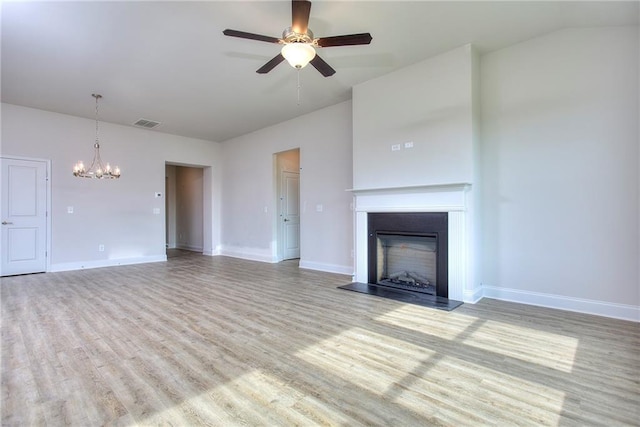 111 Ginger Trl, Homer, GA 30547 - unfurnished living room featuring a ceiling fan, wood finished floors, a chandelier, a fireplace with raised hearth, and baseboards