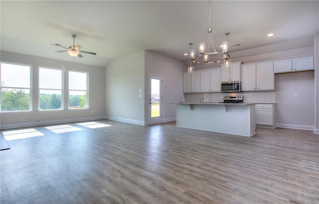 111 Ginger Trl, Homer, GA 30547 - kitchen with stainless steel microwave, range with electric cooktop, open floor plan, baseboards, and a chandelier