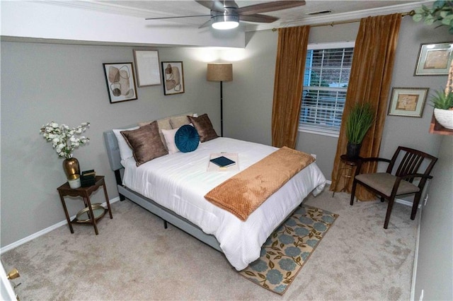 carpeted bedroom featuring ceiling fan and crown molding