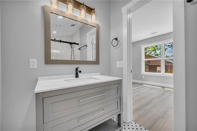 bathroom featuring a shower with door, vanity, and wood-type flooring