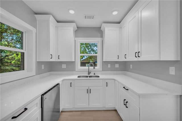 kitchen featuring sink, stainless steel fridge, white cabinetry, and a healthy amount of sunlight