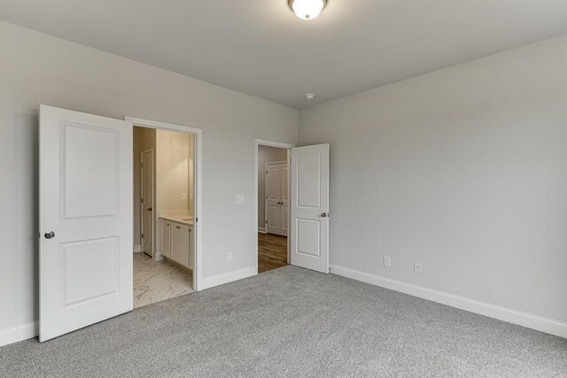 199 Montview Dr, Jefferson, GA 30549 - unfurnished bedroom featuring light carpet, baseboards, and connected bathroom