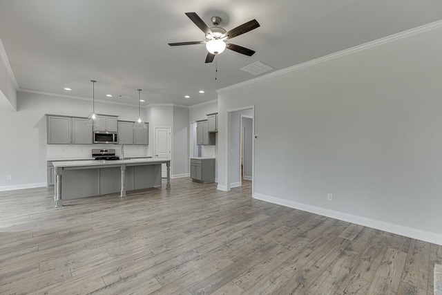 199 Montview Dr, Jefferson, GA 30549 - kitchen featuring a center island with sink, appliances with stainless steel finishes, hanging light fixtures, gray cabinets, and light countertops