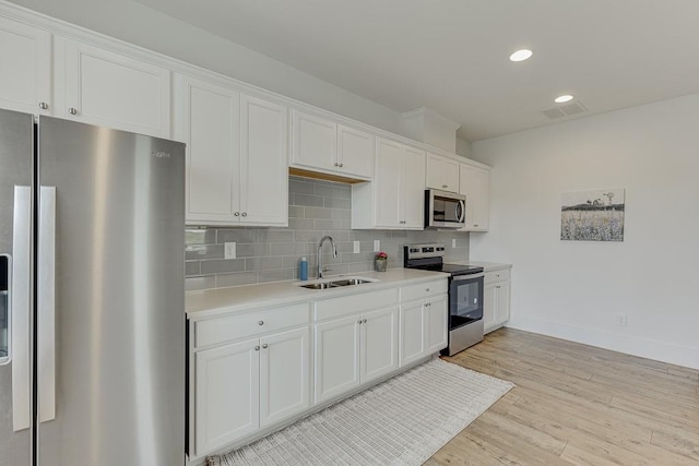 199 Montview Dr, Jefferson, GA 30549 - kitchen featuring white cabinets, a sink, stainless steel appliances, light countertops, and backsplash