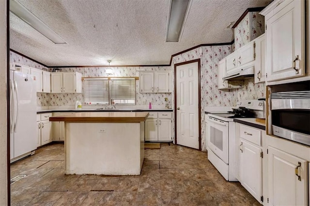 kitchen with white appliances, a textured ceiling, a center island, and white cabinetry