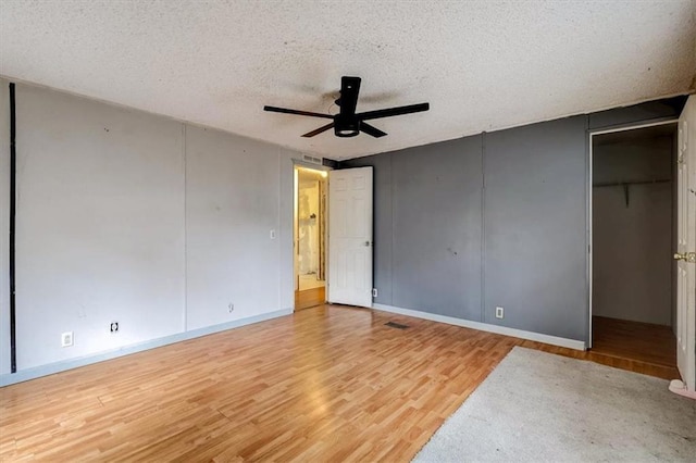 unfurnished bedroom with a textured ceiling, ceiling fan, and light wood-type flooring