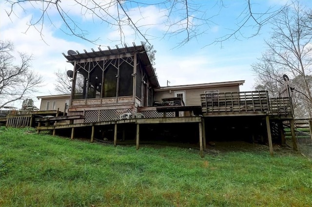 back of property with a sunroom, a wooden deck, and a yard