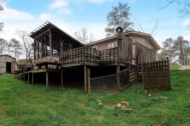 rear view of property with a deck and a yard