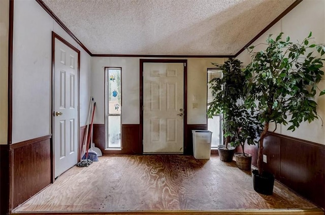 entryway with ornamental molding and a textured ceiling