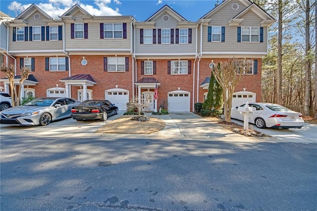 view of property with a garage, driveway, and brick siding