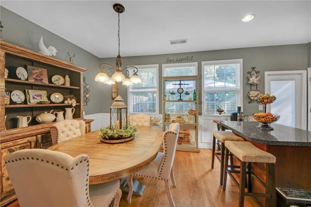 dining room with a chandelier, light wood-style flooring, recessed lighting, a wainscoted wall, and visible vents