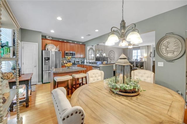 dining room with a chandelier, light wood-style flooring, and recessed lighting