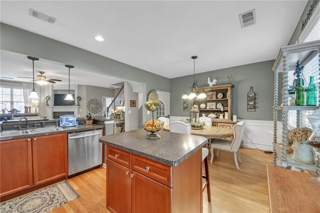 kitchen with a sink, dark countertops, visible vents, and dishwasher