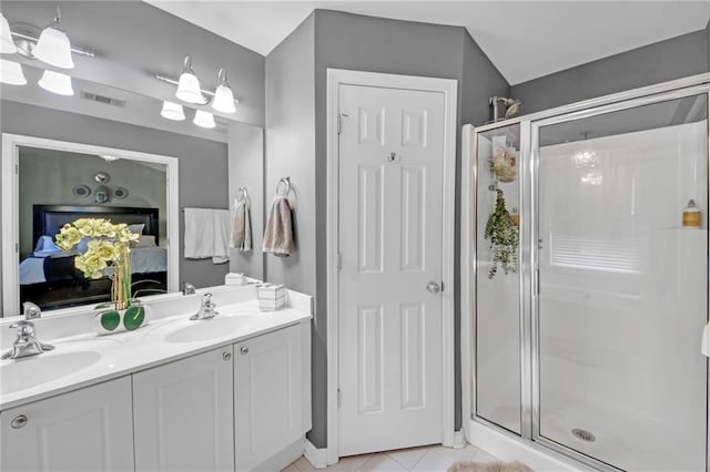 full bath with a stall shower, tile patterned floors, a sink, and ensuite bathroom