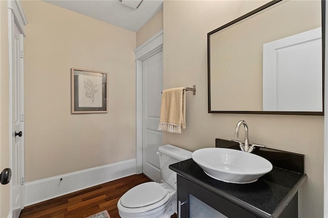 bathroom featuring vanity, baseboards, toilet, and wood finished floors