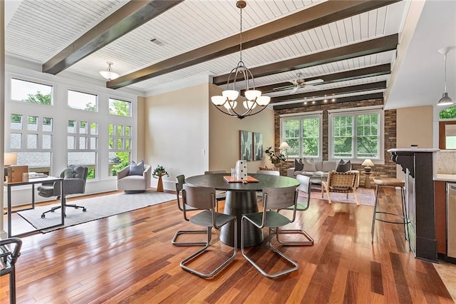 dining space with a chandelier, beamed ceiling, visible vents, and wood finished floors