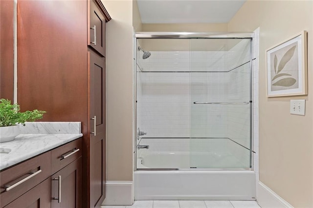 full bath featuring baseboards, tile patterned flooring, bath / shower combo with glass door, and vanity
