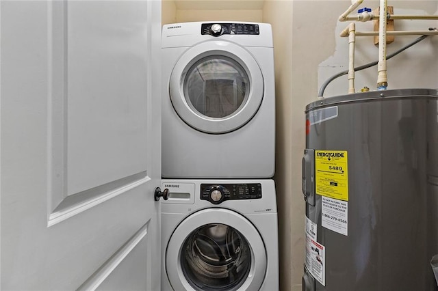 washroom featuring laundry area, stacked washer / drying machine, and electric water heater