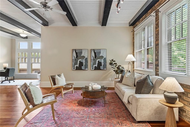 living area with plenty of natural light, wood finished floors, and beamed ceiling