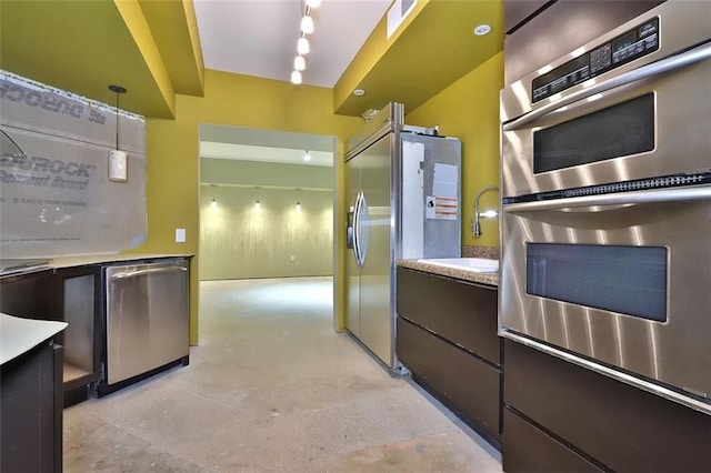 kitchen with stainless steel appliances, light countertops, a sink, and dark brown cabinets