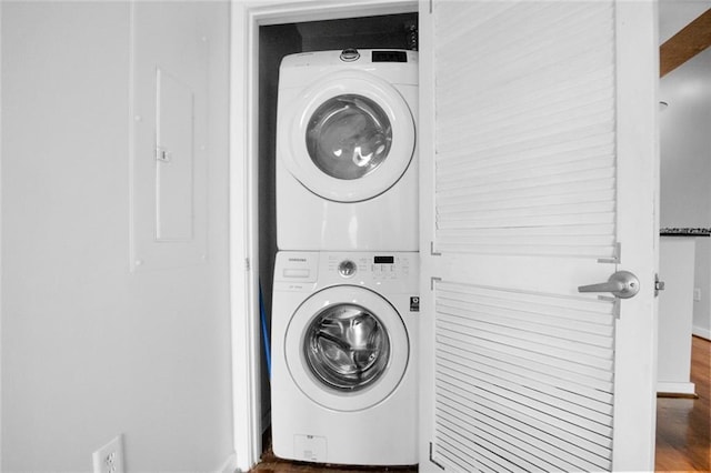 860 Peachtree St NE Unit 909, Atlanta, GA 30308 - laundry room featuring estacked washer and dryer, wood finished floors, and baseboards