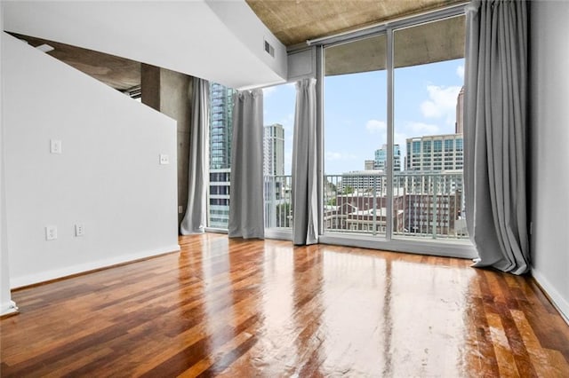 860 Peachtree St NE Unit 909, Atlanta, GA 30308 - empty room with a view of city, wood finished floors, a wall of windows, and baseboards