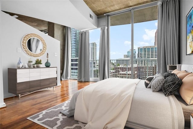 860 Peachtree St NE Unit 909, Atlanta, GA 30308 - bedroom with a city view, wood finished floors, access to outside, and a wall of windows