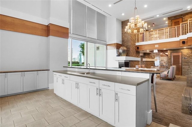 860 Peachtree St NE Unit 909, Atlanta, GA 30308 - kitchen with a towering ceiling, a sink, a chandelier, a fireplace, and backsplash